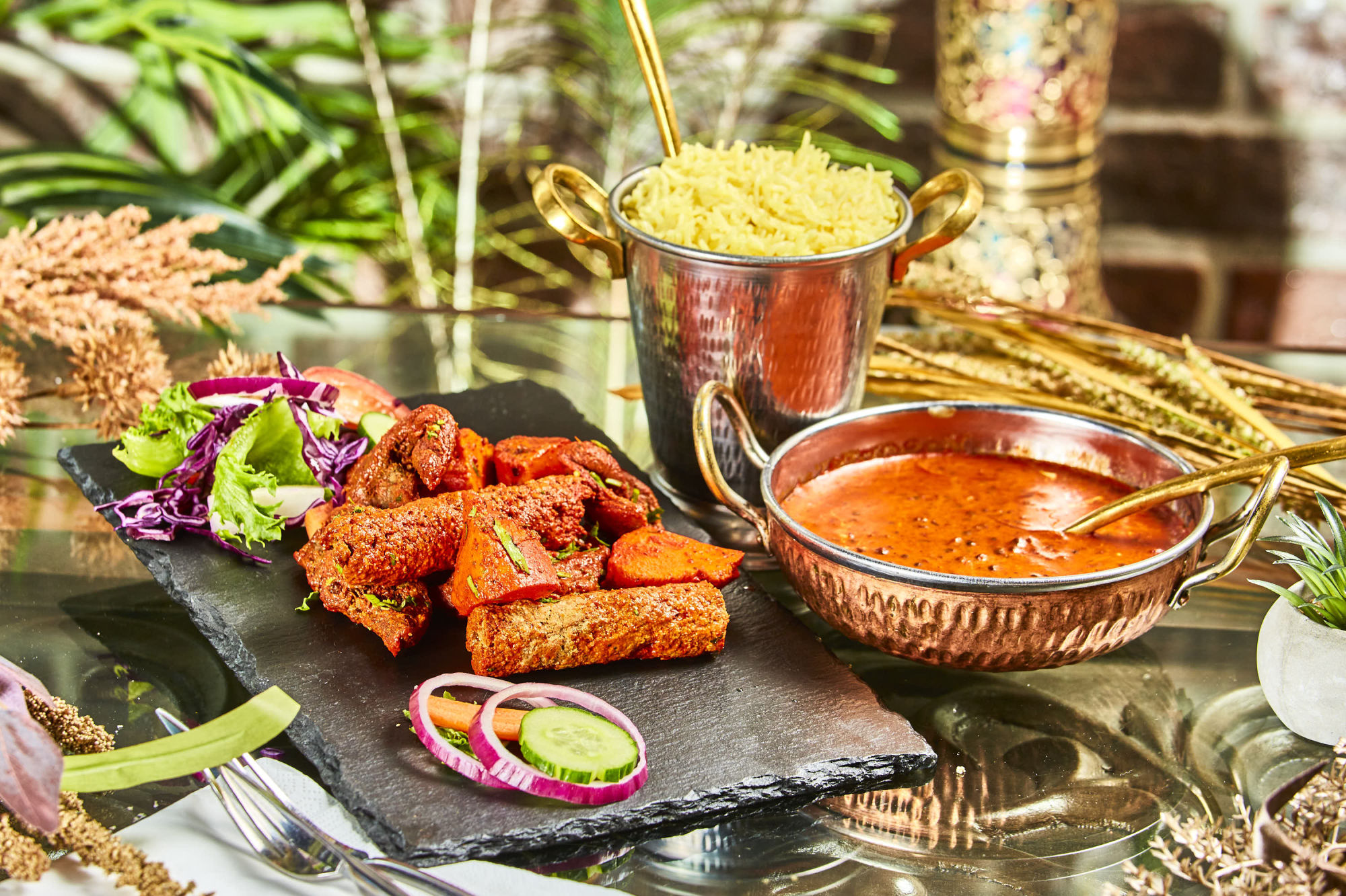 Tandoori-retter med ris, salat og sauser servert på bordet hos Koriander